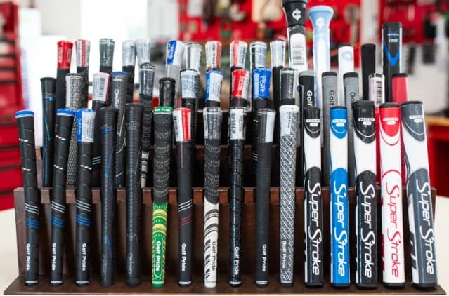 The grip wall at the GolfX workshop — corded, rubber, midsize, and putter grips